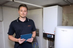 Henry Grünwald neben einer Wärmepumpe